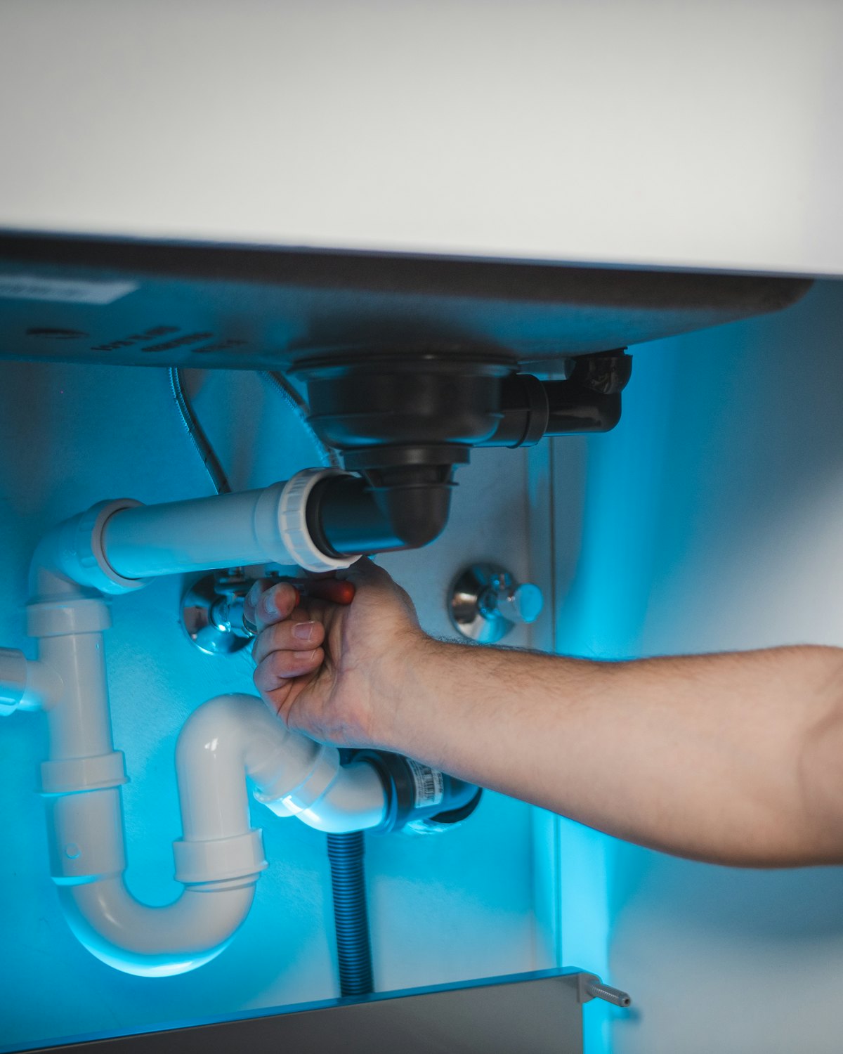 Plumber repairing pipework inside an opened wall